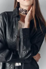Camisa de cuero ovino negro con efecto arrugado, de moldería amplia, con cuello camisero y botones a presión con logo.