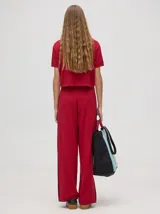 Chomba corta color rojo, con cuello camisero con rayas celestes y negras, logo bordado en el pecho y mangas cortas.