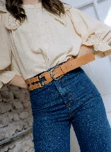 Cinturón de cuero color marrón, con hebilla metálica plateada de doble arco y detalles de remaches.