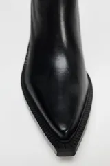 Bota de cuero negra con caña alta, punta cuadrada y tacón ancho.