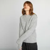 Sweater gris de punto grueso con cuello alto y mangas largas.