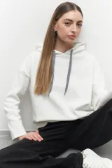 Canguro blanco de algodón con capucha y cordones, diseño de manga larga y corte holgado.