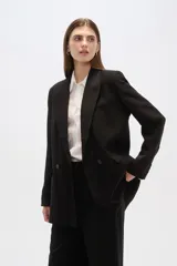 Blazer negro de corte holgado, con cuello solapa, cierre con doble botón y bolsillos laterales con solapa.