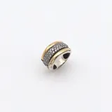 Anillo ancho de plata con detalles en oro y circonias.