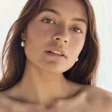 Par de aros colgantes con perlas de agua dulce y detalles en acero quirúrgico con acabado en oro de 18k.