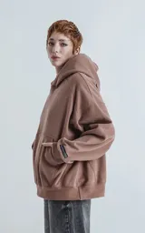Hoodie marrón confeccionado en frisa gamuzada 100% algodón, de calce oversize crop. Tiene bolsillo canguro y capucha forrada.