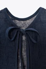 Vestido midi azul marino semitransparente de punto fino con efecto arrugado, cuello redondo, manga corta y aberturas laterales en el bajo. Cierre en la espalda con lazo.