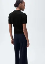 Jersey de punto calado color crudo, de manga corta con cuello polo y cierre de botones.