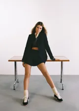 Minifalda azul marino con estampado de raya diplomática, corte ajustado, cierre lateral invisible y forro interior.