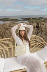 Cartera tejida a crochet con hilo 100% de algodón, con diseño a rayas y volados bordeando la cartera extendiéndose hacia la manija.