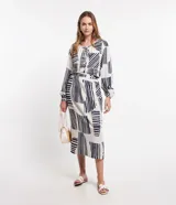 Camisa amplia de viscolino con estampado geométrico en azul marino sobre fondo crudo. Tiene cuello redondo con lazo, mangas largas abullonadas y abotonadura frontal.