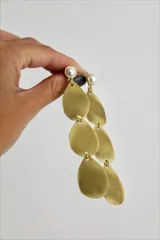 Aros colgantes dorados con perlas y piezas en forma de lágrima.