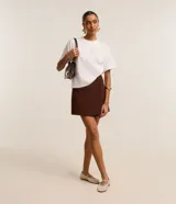 Blusa blanca de algodón con cuello redondo, mangas cortas y apliques de flores de tela en el hombro.
