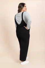 Mono enterizo negro de corte holgado, con tirantes ajustables y bolsillos delanteros.