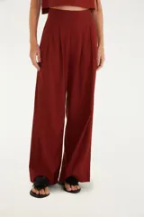 Pantalón de vestir color ladrillo, de corte amplio y tiro alto, con pinzas en la cintura y cierre invisible.