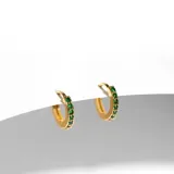 Par de argollas doradas pequeñas con cristales verde esmeralda en el frente.