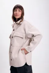 Sobrecamisa beige de paño con cuello clásico, cierre frontal con botones a tono, dos bolsillos de parche en el pecho y corte holgado.