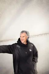 Canguro negro oversize con capucha y bolsillos laterales. Presenta un diseño estampado en gris plata con motivos esotéricos: estrellas, constelaciones y un unicornio alado.