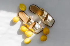 Sandalias bajas color camel con tiras anchas entrelazadas formando un nudo.