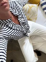 Blusa de manga larga a rayas verticales blancas y negras con volados en el frente y en el escote.