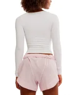 Top blanco de manga larga, textura suave y elástico con escote redondeado.