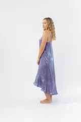 Vestido midi color lila metálico de breteles finos regulables, escote en V y ruedo asimétrico con leve vuelo.