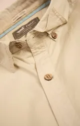 Camisa amarilla de algodón orgánico, manga larga con botones de madera, cuello italiano, calce regular, bolsillo de pecho con logo bordado.
