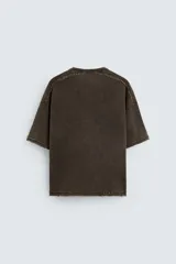 Camiseta gris de punto con efecto lavado, corte holgado, cuello redondo y mangas cortas.