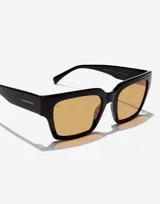 Lentes de sol unisex Hawkers modelo Mate Black Mustard Eco, con montura cuadrada negra y cristales color mostaza.