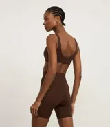 Conjunto deportivo de dos piezas, color fucsia vibrante, compuesto por un top deportivo de escote redondo y una bermuda ciclista de tiro alto.