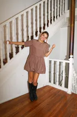 Vestido corto negro con corte en la cintura y falda balloon, de manga corta y cuello redondo.