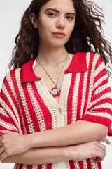 Camisa tejida a crochet con rayas verticales rojas y crudas, cuello polo y cierre frontal con botones.