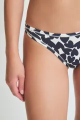 Conjunto de ropa interior color crema, compuesto por un corpiño de encaje con breteles finos y una bombacha tipo colaless con detalle de encaje en la cintura.