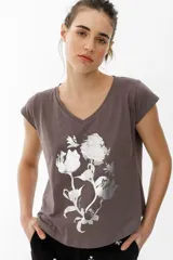 Remera gris con cuello en V, mangas cortas y estampado de flores plateadas metalizadas.