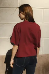Remera negra de algodón con corte cuadrado, cuello redondo y logo bordado en color naranja.