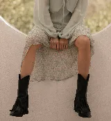 Botas negras de cuero con flecos y taco bajo.