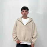 Campera de felpa beige con cierre frontal y diseño amplio.