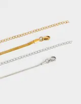 Set de dos collares cortos de acero quirúrgico, uno dorado de eslabones planos tipo espiga y otro plateado de eslabones finos.