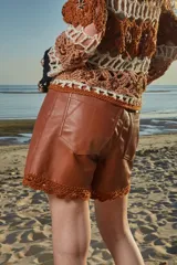 Short de cuero color marrón con terminaciones en crochet de hilo de algodón.