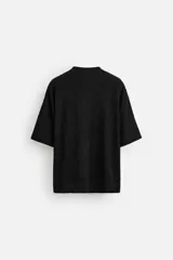 Sudadera negra de tejido texturizado con mezcla de algodón. Corte relaxed fit, cuello redondo y manga corta.