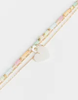 Collar corto dorado de tres cadenas con cuentas de colores y dijes de corazón y flor.