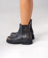 Botas Chelsea de cuero vacuno negro con elásticos laterales, cierre interno y suela de goma artesanal.