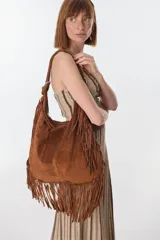 Bolso bandolera de gamuza color beige con flecos largos en la parte inferior.