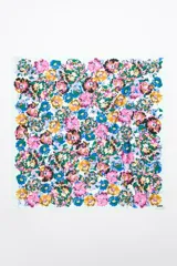 Pañuelo cuadrado con estampado floral en tonos vibrantes, modelo personalizado con etiqueta logotipada.