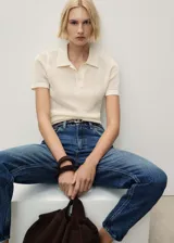 Pantalón de jean azul de corte mom, con tiro alto, cinco bolsillos y cierre de cremallera y botón.