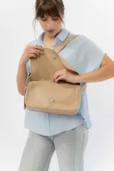 Bandolera moderna de eco cuero texturado color negro, con solapa frontal con cierre magnético oculto y correa regulable para llevar al hombro o cruzada.