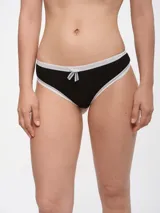 Colaless blanca de algodón con terminaciones de puntilla negra y moño decorativo.