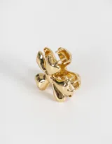 Broche dorado con forma de flor de cinco pétalos redondeados y centro circular.