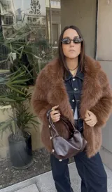 Campera de pelo sintético color beige, con cuello solapa, cierre con botones y bolsillos laterales.