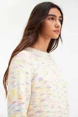 Sweater de punto color crudo con motas de colores pastel, de corte clásico y cuello redondo.